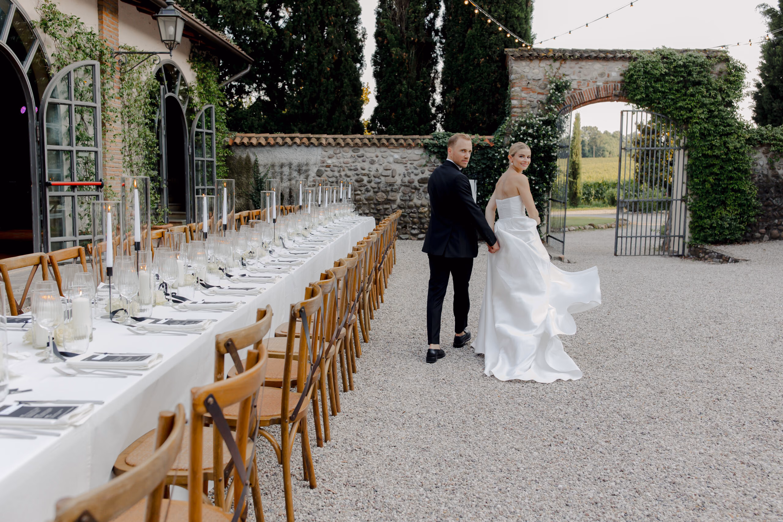 Festlich gedeckte lange Tafel im Innenhof einer Villa